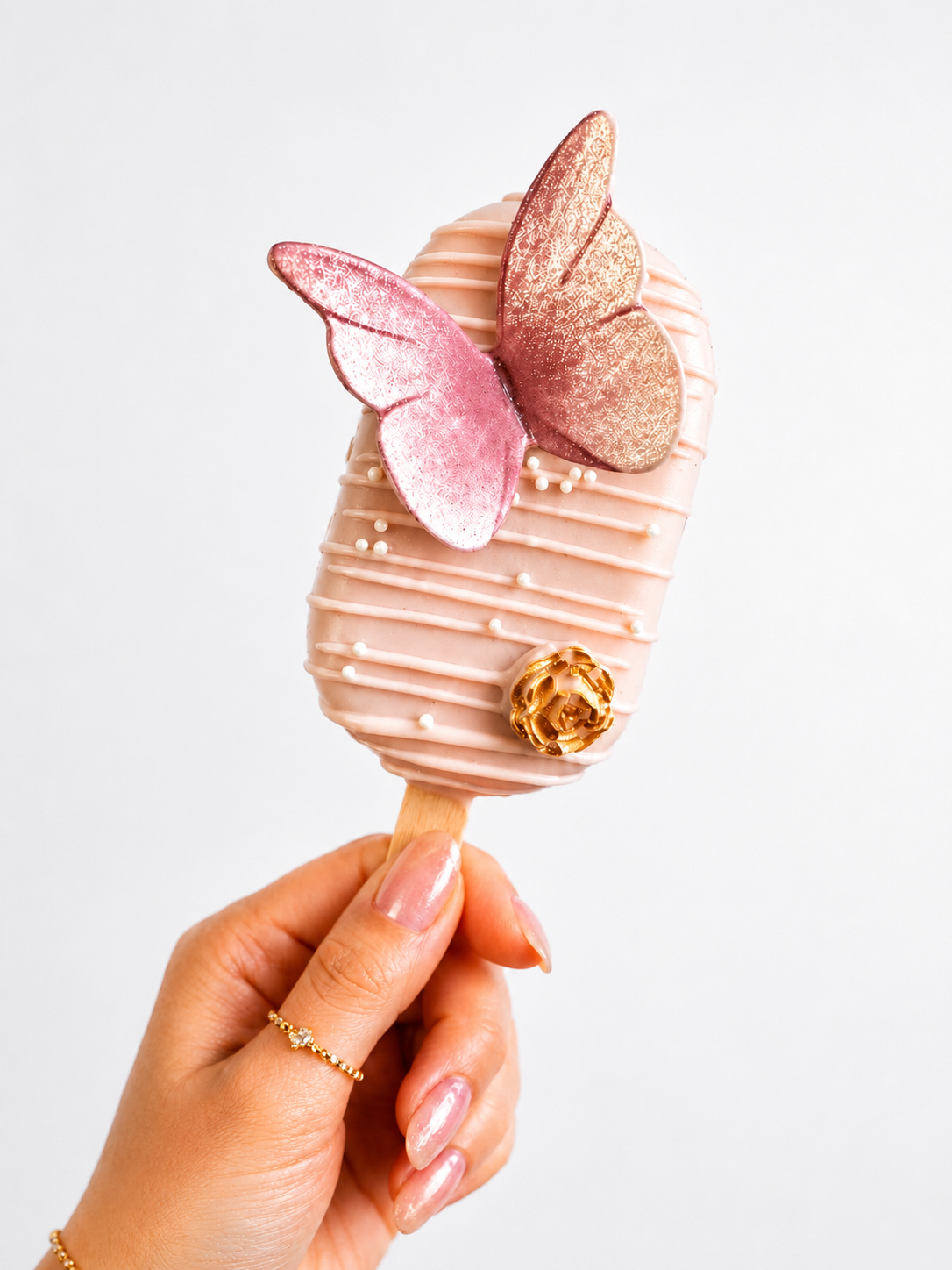 Signature blush pink butterfly cakesicle with gold rose